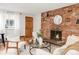 Bright living room showcases a brick fireplace, modern furnishings, and hardwood flooring at 155 S Pennsylvania St # 205, Denver, CO 80209