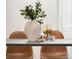 Tasteful dining table arrangement with olive leaf centerpiece, decorative accents, and modern chairs, creating an inviting ambiance at 155 S Pennsylvania St # 205, Denver, CO 80209