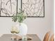 Elegant dining table setting featuring decorative vase, glassware, and stylish minimalist wall art enhancing the dining experience at 155 S Pennsylvania St # 205, Denver, CO 80209