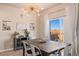 Charming dining room featuring a wooden table, modern chandelier, and sliding glass door at 244 Chipeta Way, Lochbuie, CO 80603