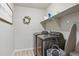 Well-equipped laundry room with modern washer and dryer units and shelving at 244 Chipeta Way, Lochbuie, CO 80603