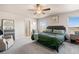 Spacious bedroom featuring an upholstered headboard, ceiling fan, and plush carpeting at 244 Chipeta Way, Lochbuie, CO 80603