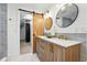 Bright bathroom featuring dual sinks, stylish mirrors, and a barn door leading to a closet at 31 Wild Tiger Ln, Boulder, CO 80302