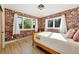 Cozy bedroom with exposed brick walls, a large window for natural light, and comfortable decor and furniture at 31 Wild Tiger Ln, Boulder, CO 80302