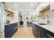 Modern kitchen with navy and white cabinets, an eat-in area with a wood burning stove and stainless steel appliances at 31 Wild Tiger Ln, Boulder, CO 80302