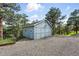Exterior shot of a light blue shed located near green trees and a gravel driveway at 31 Wild Tiger Ln, Boulder, CO 80302