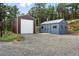A garage and shed are constructed on a gravel lot and surrounded by lush green trees at 31 Wild Tiger Ln, Boulder, CO 80302