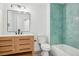 Contemporary bathroom with wood vanity, white marble countertop, and unique green tile accents at 1057 English Sparrow Trl, Highlands Ranch, CO 80129