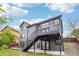 Exterior view of the rear of the gray home featuring a staircase leading to a second-story deck at 1057 English Sparrow Trl, Highlands Ranch, CO 80129