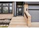 Inviting front entrance with brick accents, gray siding, and a well-maintained walkway at 1057 English Sparrow Trl, Highlands Ranch, CO 80129