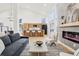 Bright open-concept living room with hardwood floors, modern fireplace, and kitchen area at 1057 English Sparrow Trl, Highlands Ranch, CO 80129