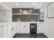 Stylish wet bar features black and white backsplash, floating shelf, and built-in wine cooler at 1057 English Sparrow Trl, Highlands Ranch, CO 80129