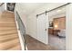 Light hallway with sliding barn door and wooden staircase at 1555 Perry St, Denver, CO 80204