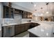 Finished basement wet bar with granite countertop, stainless steel dishwasher, custom cabinetry, and modern lighting at 10994 Shadowbrook Cir, Highlands Ranch, CO 80130