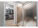 Bathroom featuring a glass-enclosed shower and an open walk-in closet for optimal storage solutions at 10994 Shadowbrook Cir, Highlands Ranch, CO 80130