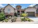 Charming front entrance with stone accents and beautifully landscaped front yard at 10994 Shadowbrook Cir, Highlands Ranch, CO 80130