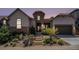 Stunning home exterior with stone accents, a front lawn, and landscaped garden beds at 10994 Shadowbrook Cir, Highlands Ranch, CO 80130