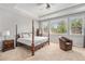 Bright main bedroom boasting a four-poster bed, tray ceiling, and large windows offering serene views at 10994 Shadowbrook Cir, Highlands Ranch, CO 80130