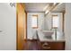 Modern bathroom with a vessel sink, wood vanity, large mirror, and natural light from window at 2340 Curtis St # 1, Denver, CO 80205