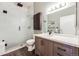Modern bathroom with glass shower, wood vanity, and decorative mirror at 1521 Central St # 2B, Denver, CO 80211
