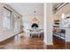 Bright dining area boasts hardwood floors, modern lighting, and views to the outdoor patio and open concept kitchen at 1521 Central St # 2B, Denver, CO 80211
