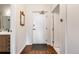 Hallway with a decorative mirror, hardwood floors, and a bright white entry door at 1521 Central St # 2B, Denver, CO 80211
