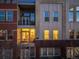 Townhouse exterior showing outdoor patio area with furniture and an illuminated kitchen at 1521 Central St # 2B, Denver, CO 80211