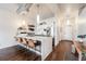 Modern kitchen with barstools, stainless steel appliances, and white cabinets with an island cooktop at 1521 Central St # 2B, Denver, CO 80211