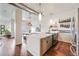 Open-concept kitchen with a spacious island, stainless steel appliances, and access to the dining area and patio at 1521 Central St # 2B, Denver, CO 80211
