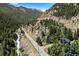 Scenic aerial view of a home nestled in the mountains, surrounded by trees and a flowing river at 205 Loop Dr, Georgetown, CO 80444
