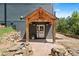 Charming home entrance with a covered porch, stone pathway, and landscaped surroundings at 205 Loop Dr, Georgetown, CO 80444