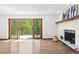 Living room showcasing hardwood floors, fireplace, white walls, and sliding glass door leading to outdoor deck at 205 Loop Dr, Georgetown, CO 80444