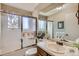 Bright bathroom featuring tub, glass shower door and sink with wood vanity at 6376 S Pierson St, Littleton, CO 80127