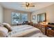 Comfortable bedroom with ceiling fan, wood dresser and neighborhood views through a window at 6376 S Pierson St, Littleton, CO 80127