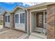 Inviting front porch with brick accents, steps to the front door, and rock landscaping at 6376 S Pierson St, Littleton, CO 80127