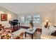 Bright living room with a piano, hardwood floors, and large windows providing ample natural light at 6376 S Pierson St, Littleton, CO 80127