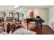 Bright living room with a piano and hardwood floors, showcasing open concept layout at 6376 S Pierson St, Littleton, CO 80127
