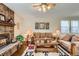 Spacious living room featuring a brick fireplace, hardwood floors, and comfortable couches at 6376 S Pierson St, Littleton, CO 80127
