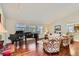 Bright living room with a piano, hardwood floors, and large windows providing ample natural light at 6376 S Pierson St, Littleton, CO 80127