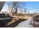 Large backyard with mature trees and partial snow cover at 6730 Ingalls St, Arvada, CO 80003