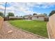 Spacious backyard with green grass, wooden fence, gravel border, and a small patio outside at 6413 W 76Th Ave, Arvada, CO 80003