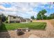 Beautiful backyard with lush lawn, mature trees, patio, and gravel area with a bench at 6413 W 76Th Ave, Arvada, CO 80003