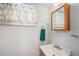 Simple bathroom featuring a vanity sink and a floral-patterned window curtain at 6413 W 76Th Ave, Arvada, CO 80003