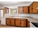 Well-lit kitchen featuring classic wood cabinets and white appliances at 6413 W 76Th Ave, Arvada, CO 80003
