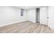 Unfurnished basement room with neutral walls, light wood-look floors, a bright window, and a closet at 1591 Holly St, Denver, CO 80220