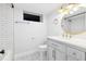 Clean bathroom with white subway tiles, a gray patterned floor, and a gold trimmed vanity mirror at 1591 Holly St, Denver, CO 80220