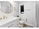 Bathroom featuring a white vanity, decorative mirrors, updated fixtures, and stylish tile flooring at 1591 Holly St, Denver, CO 80220