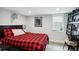 Cozy bedroom with a red plaid comforter, adjacent desk and shelving, and a decorative rhino head at 1591 Holly St, Denver, CO 80220