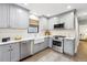 Well-lit kitchen features gray cabinets, stainless steel appliances, a farmhouse sink, and white subway tile backsplash at 1591 Holly St, Denver, CO 80220