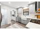 Well-lit kitchen with gray cabinets, white countertops, subway tile backsplash, and modern appliances at 1591 Holly St, Denver, CO 80220